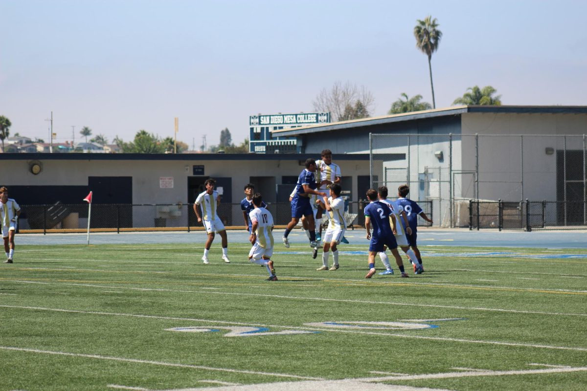 San Diego Mesa College and their opponents engage in an intense aerial battle, both teams fighting hard for possession on the field.